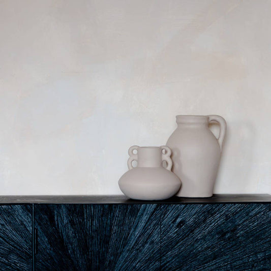 Two ceramic vases on a dark wooden surface with a light background