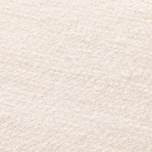Close-up of the breathable ecru cotton fabric texture on the NATURE collection fringed throw.