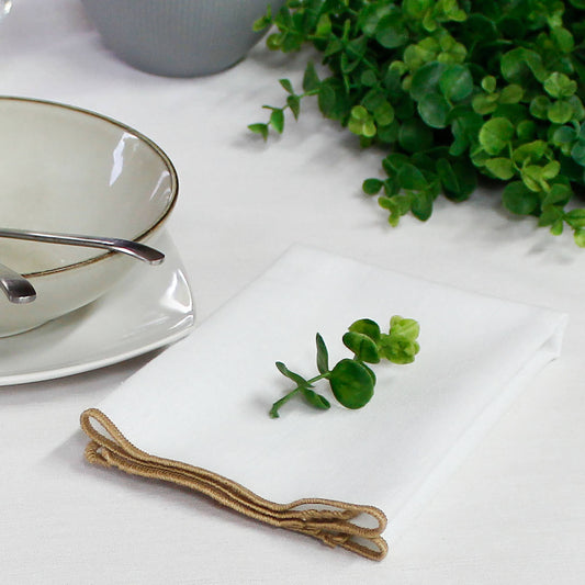 Close up of the artisanal jute festoon border on a white recycled cotton napkin showing the organic texture