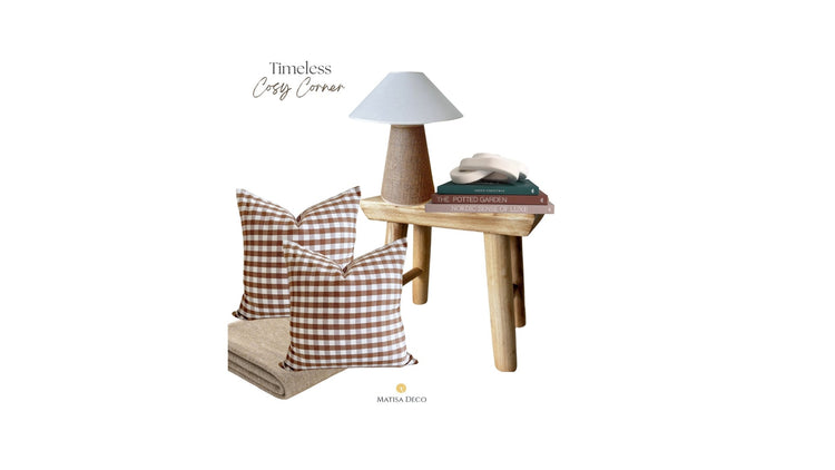 Timeless Cozy Corner with natural wood stool, Christmas and interior design books, brown cushions, cozy cotton blanket and white ornament