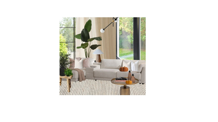 Cozy Autumn living room scene with a light beige sofa featuring a brown gingham check cushion and a flax linen jacquard cushion, styled with a soft fringed throw and rustic wood stool, illustrating warm fall home decor ideas.