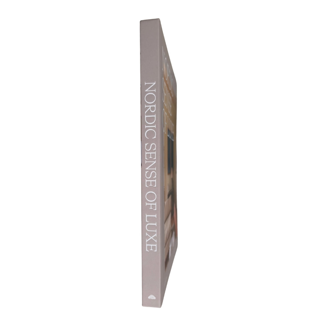 A slim hardcover book or magazine shown upright in profile on a plain white background, with the spine reading 'NORDIC SENSE OF LUXE' in large light gray text.