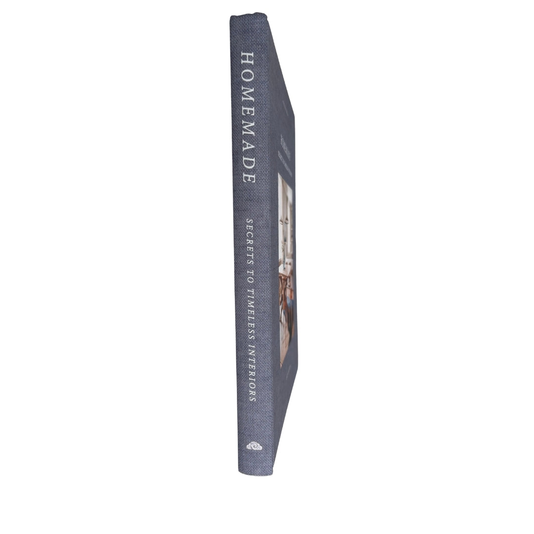 A single hardcover book standing upright on a plain white background. The spine is visible and reads “HOMEMADE” with smaller text below, and the cover appears to show an interior scene.