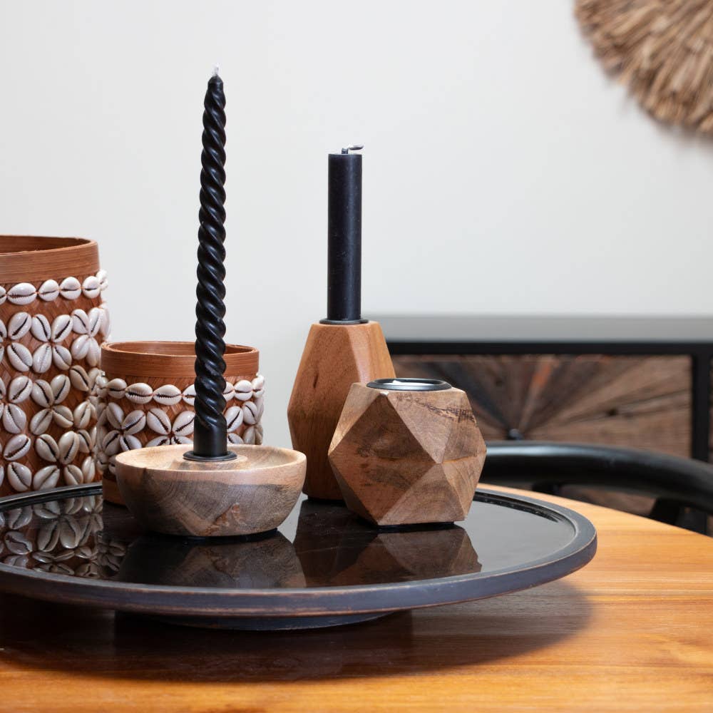 Decorative items including a twisted candle holder and geometric wooden containers on a table.