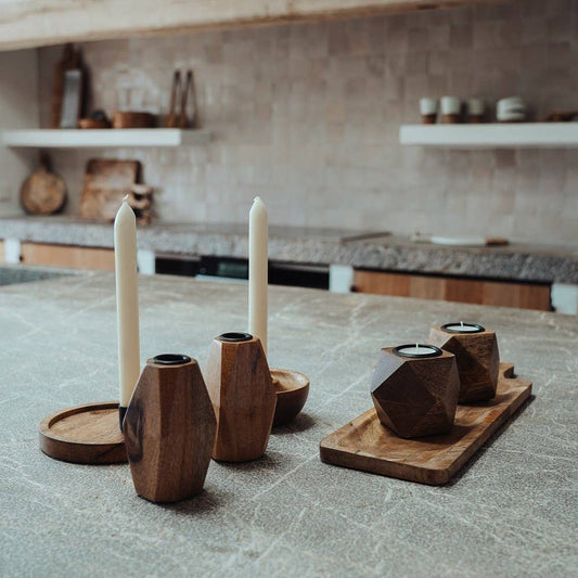Wooden candle holders on a kitchen counter with a neutral background