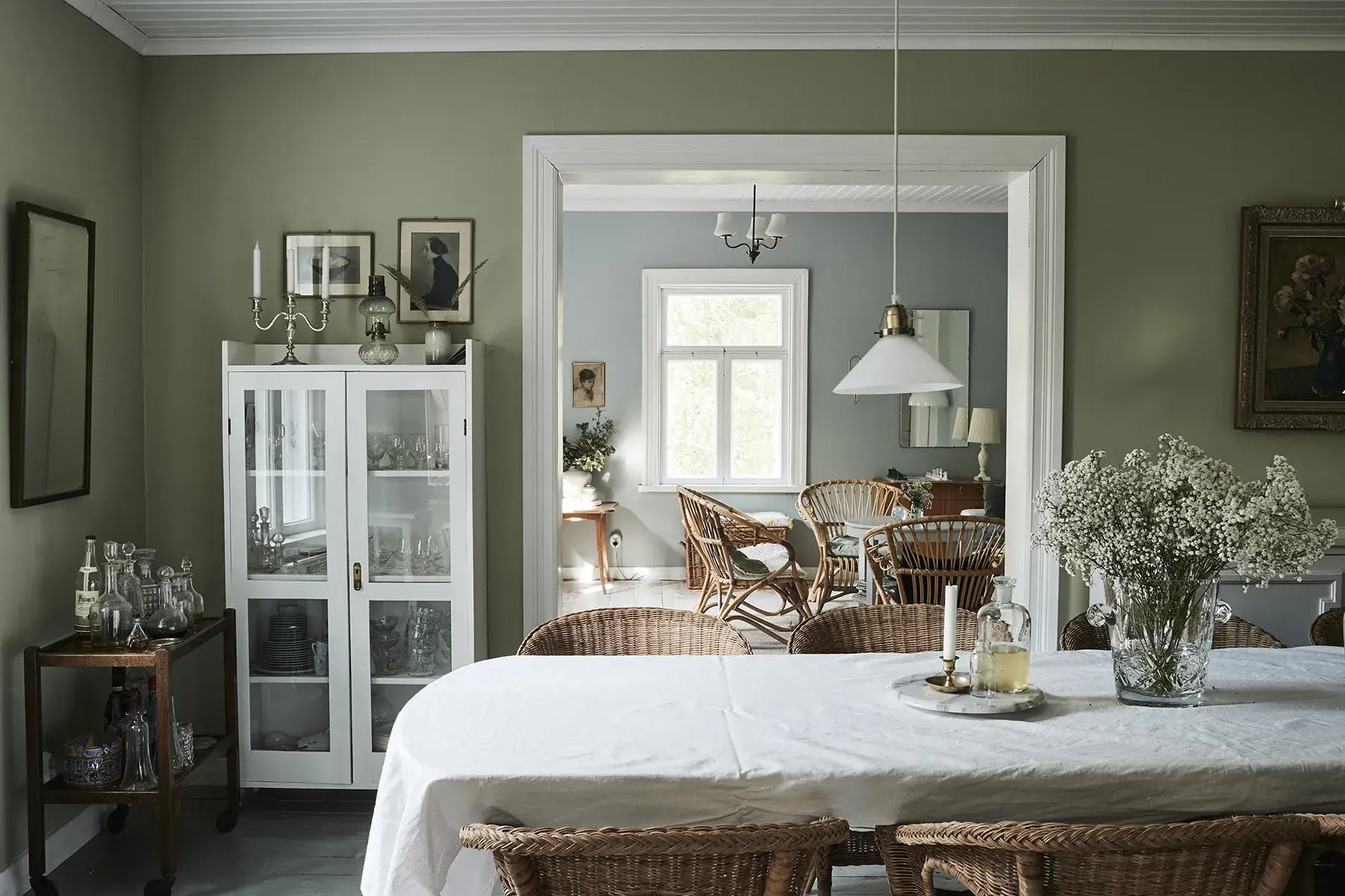 Dining room with a table set for a meal, chairs, and a cabinet.