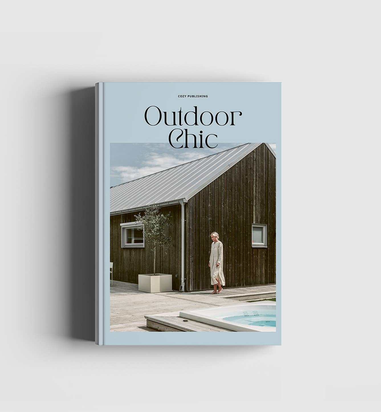 Book titled 'Outdoor Chic' with a cover featuring a person by a wooden house.
