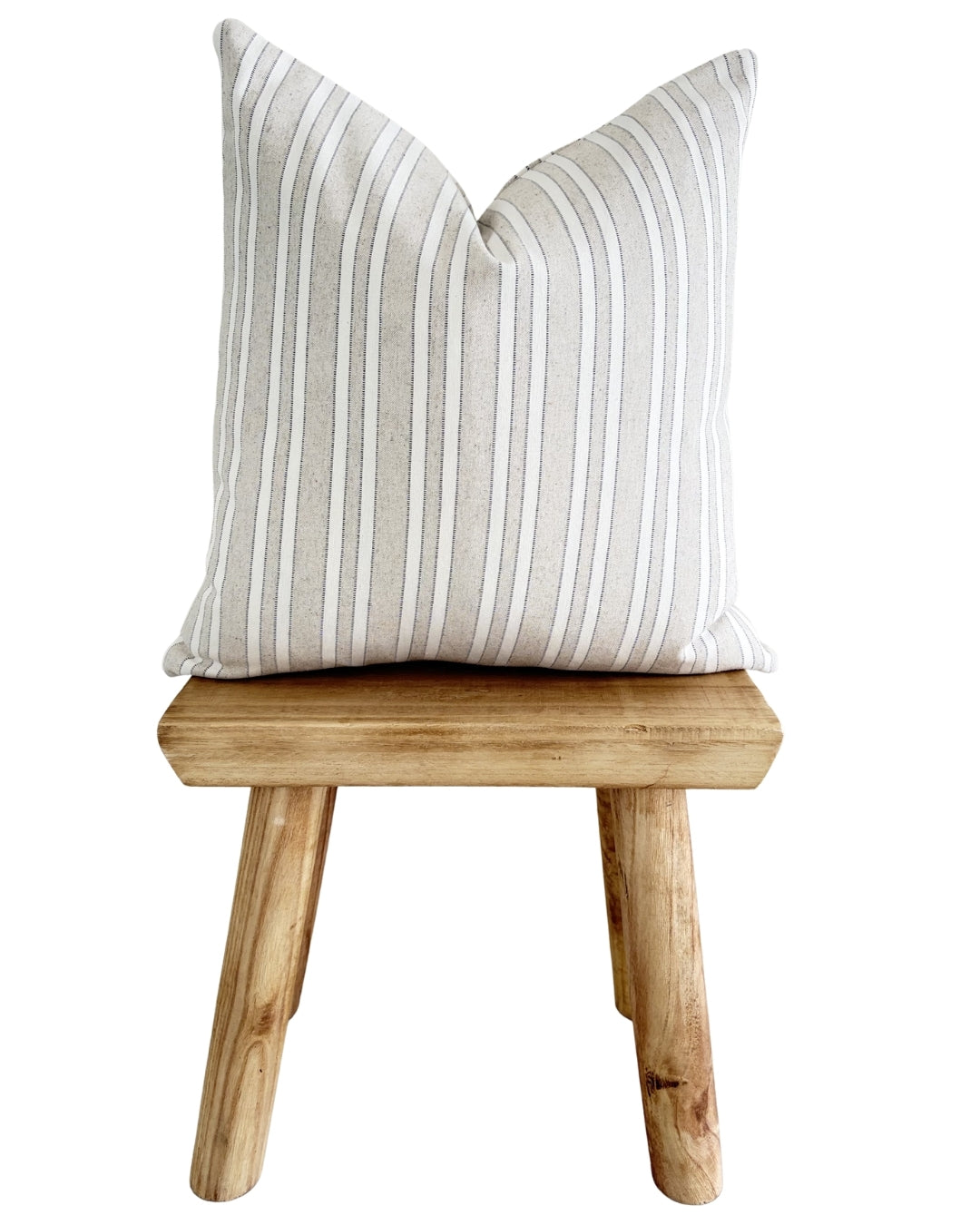 Striped pillow on a wooden stool against a white background