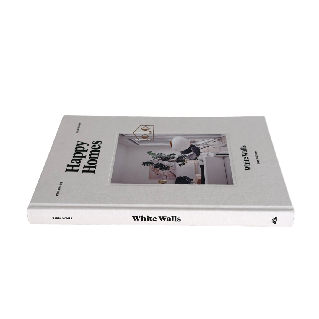 A hardcover book titled 'Happy Homes' and 'White Walls' by Happy Homes, featuring a white cover with a central photograph of a modern interior room.