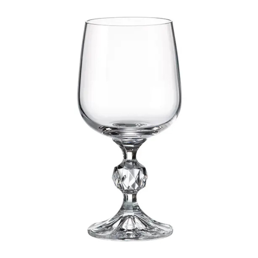 Clear glass wine glass with decorative base on a white background