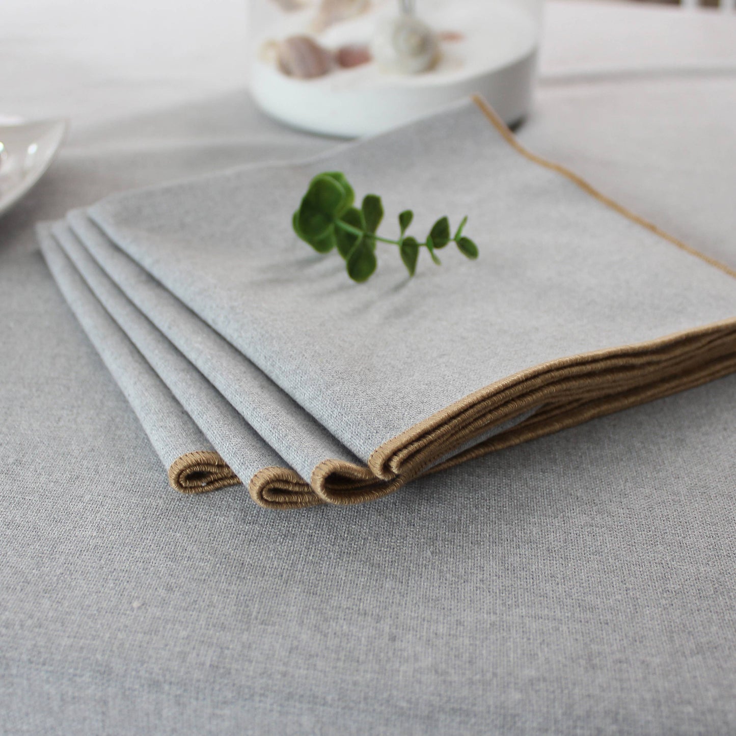 Close up of the unique non uniform texture of a silver grey recycled cotton napkin with jute festoon border.