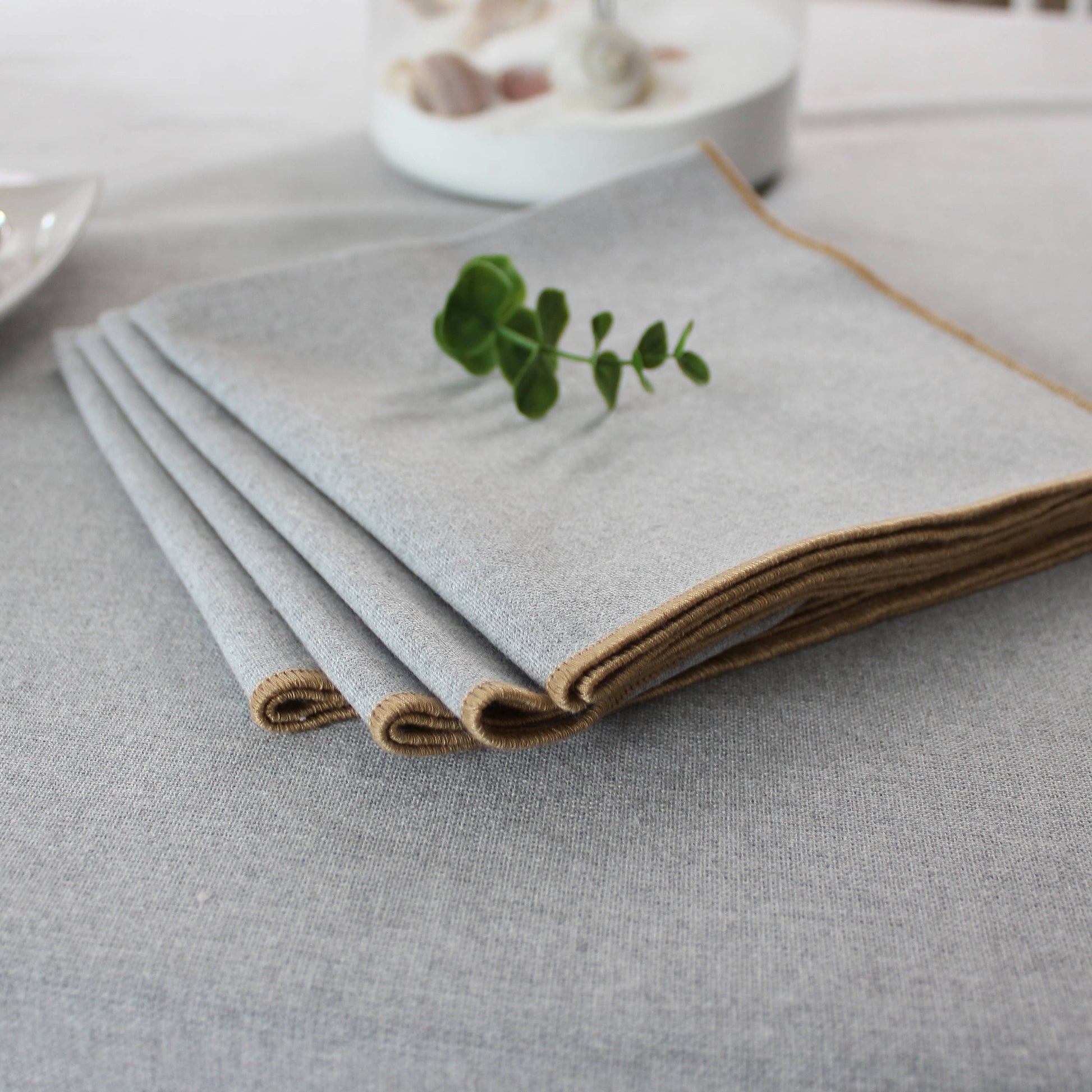 Close up of the unique non uniform texture of a silver grey recycled cotton napkin with jute festoon border.