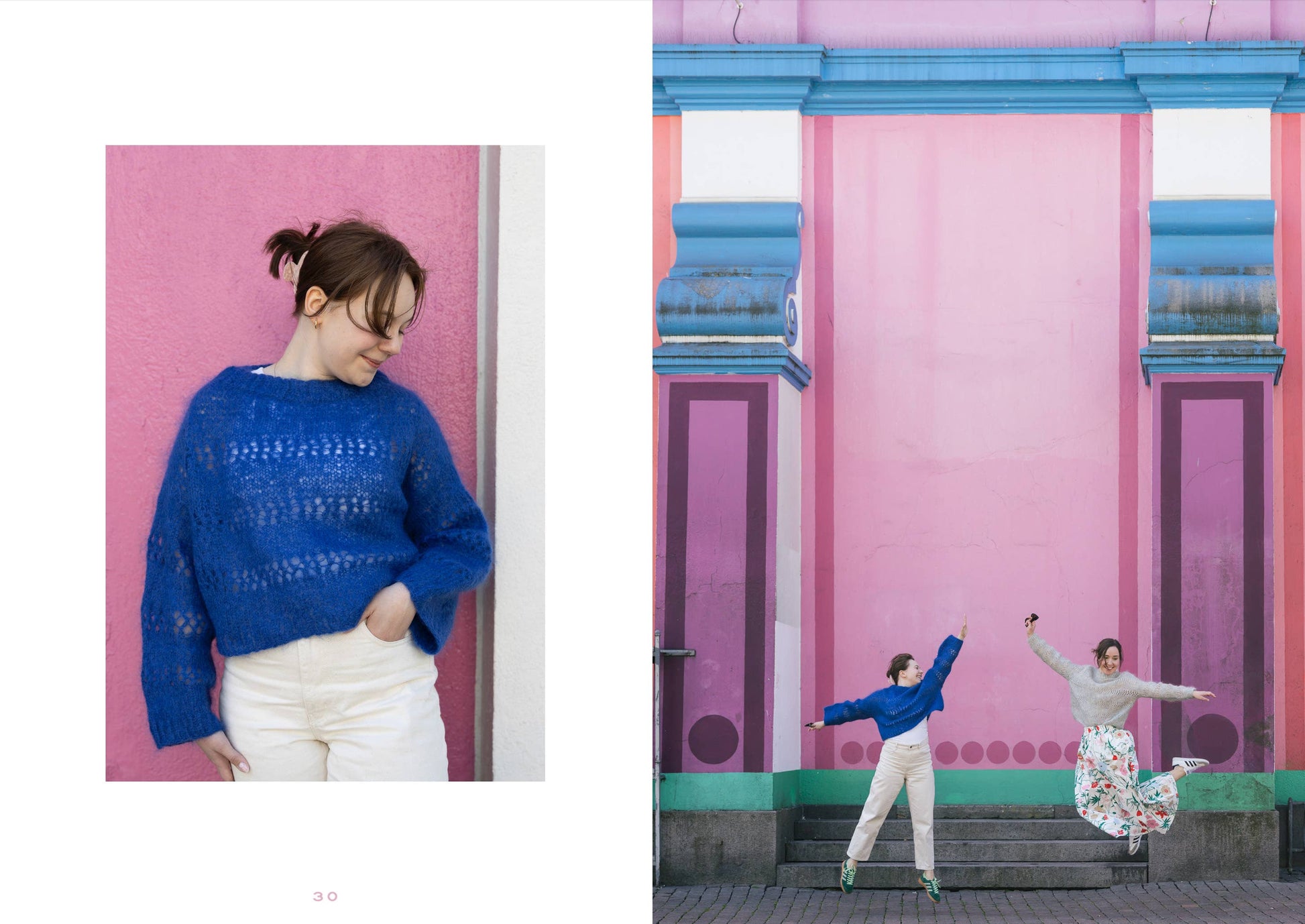 Woman in a blue sweater standing against a pink wall with another person dancing on steps.