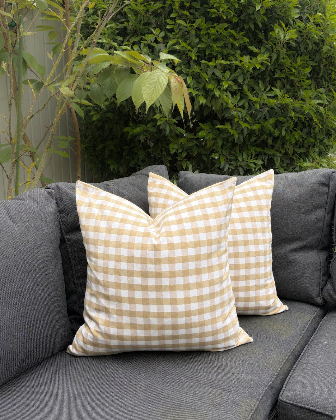 Modern garden sofa decorated with beige water-repellent gingham covers.