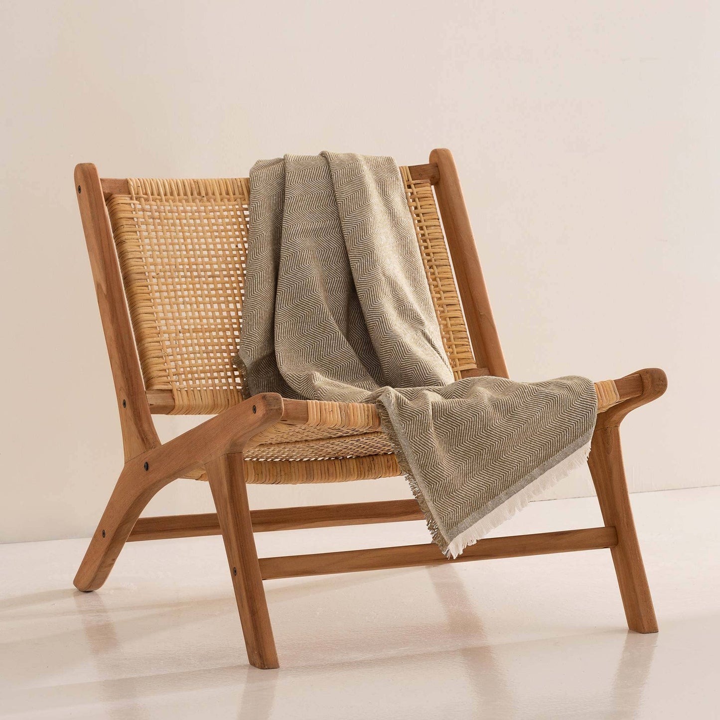 NATURE flax blanket styled as a beige earth-tone accent on a modern neutral chair.