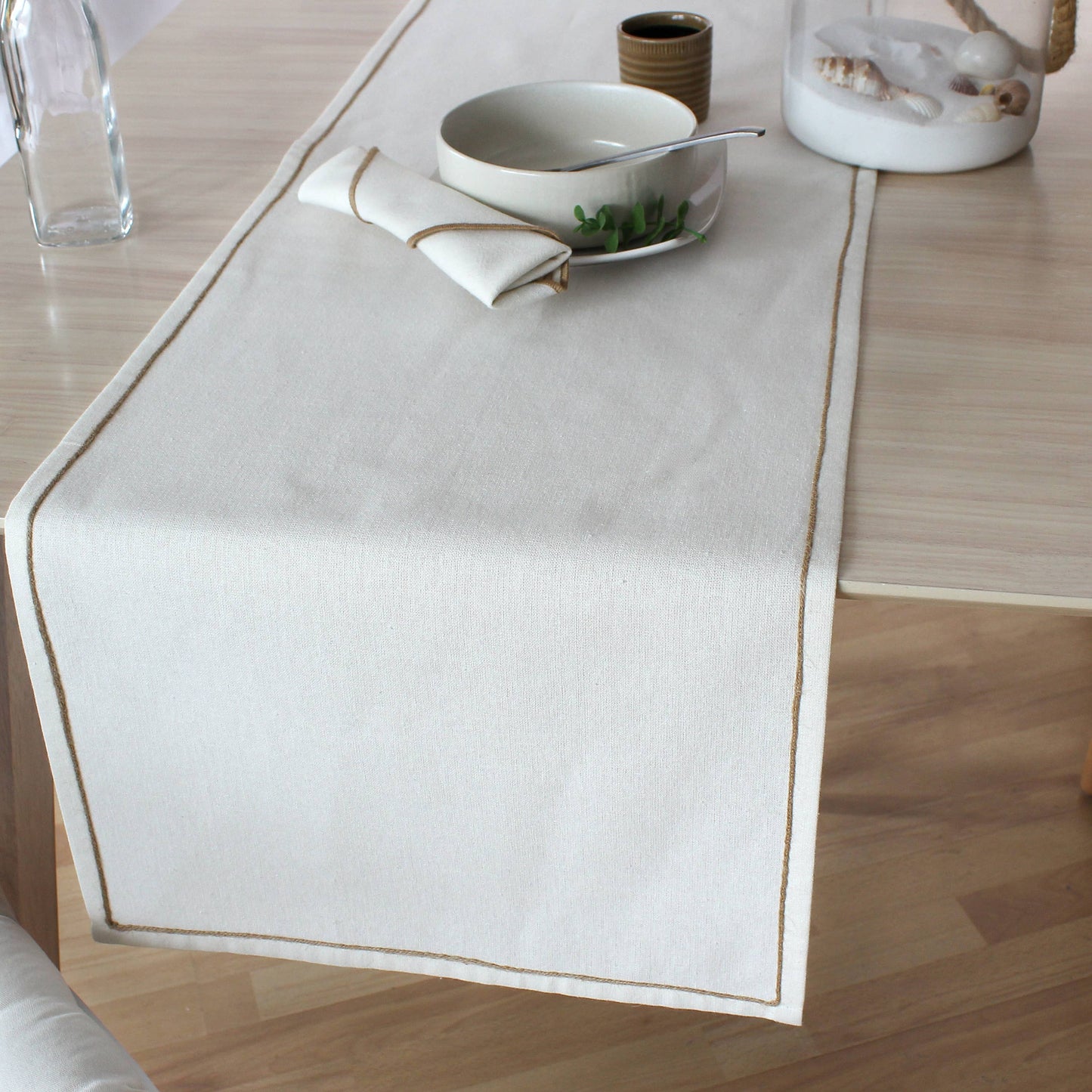 Water repellent effect on a sand colored table runner featuring liquid beading on the textured recycled fabric surface.