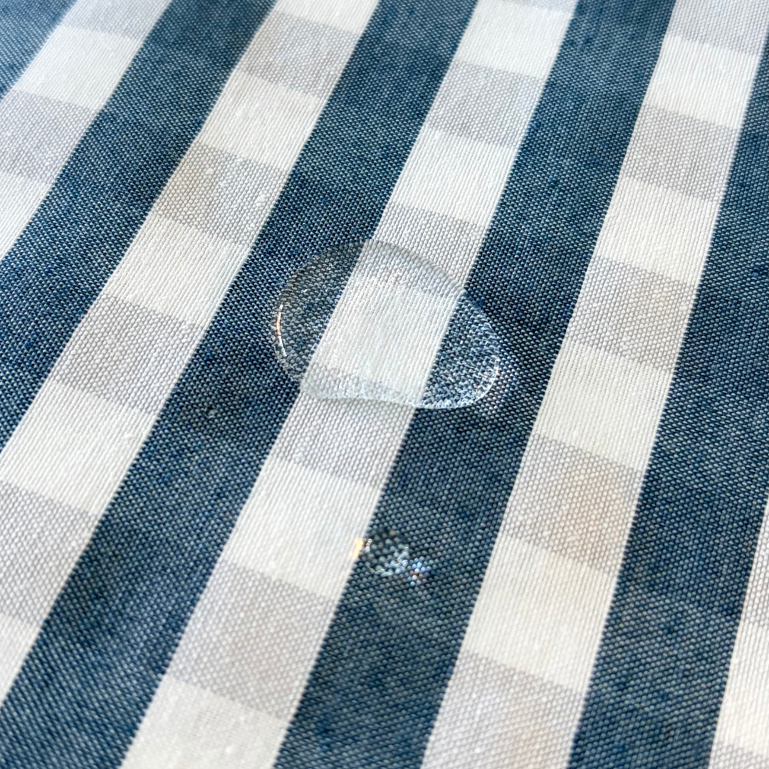 Water droplets beading on blue gingham water repellent tablecloth