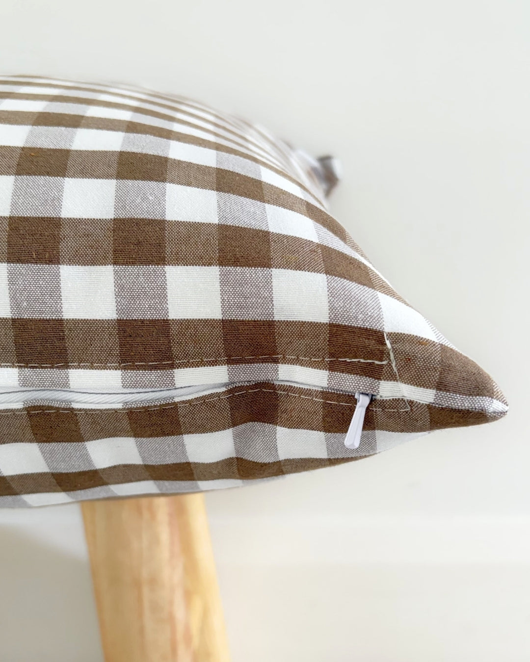 Reinforced hidden zip on brown water-repellent cushion cover.