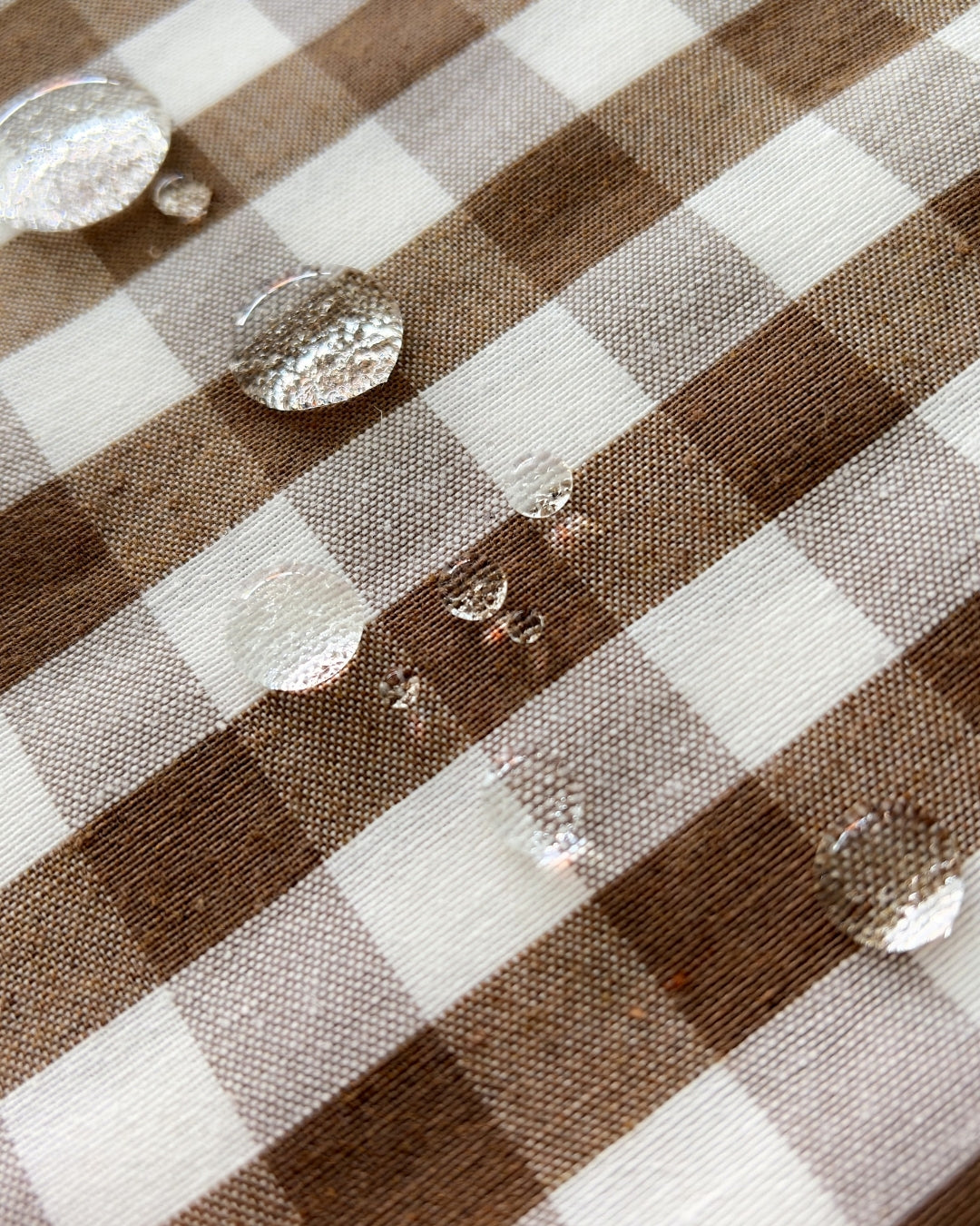 Authentic water-repellent finish on brown gingham cotton textile.