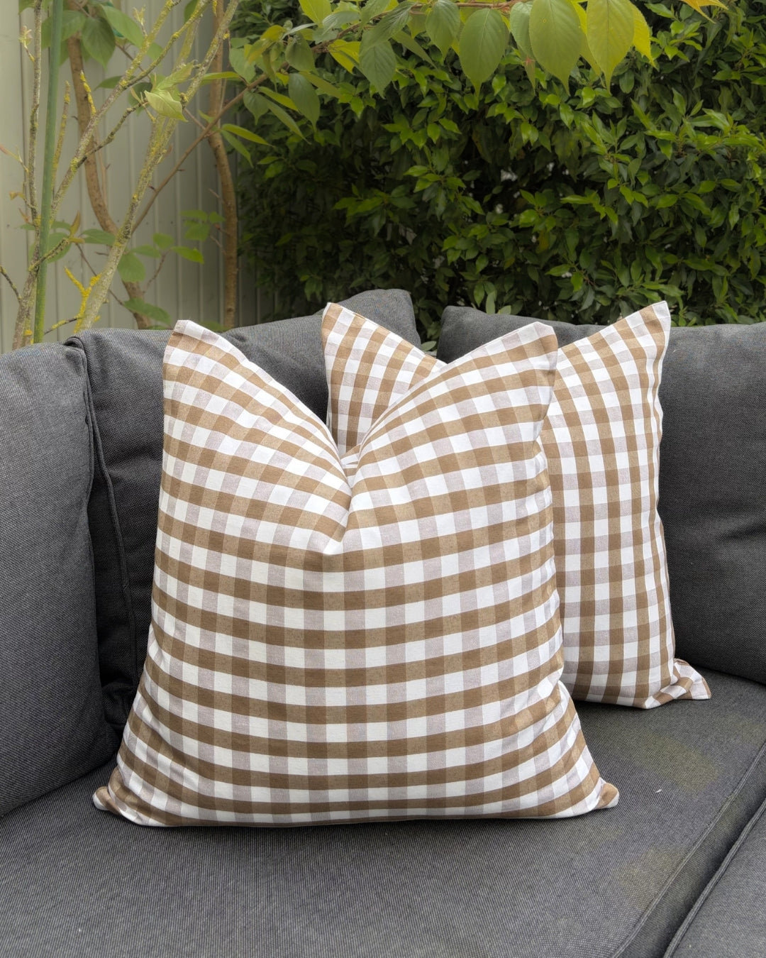 Garden sofa styling with brown water-repellent gingham covers.