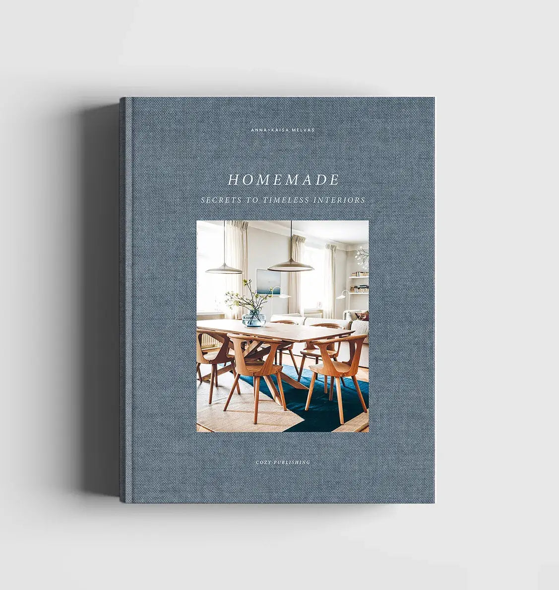 Book titled 'Homemade: Secrets to Timeless Interiors' on a gray background
