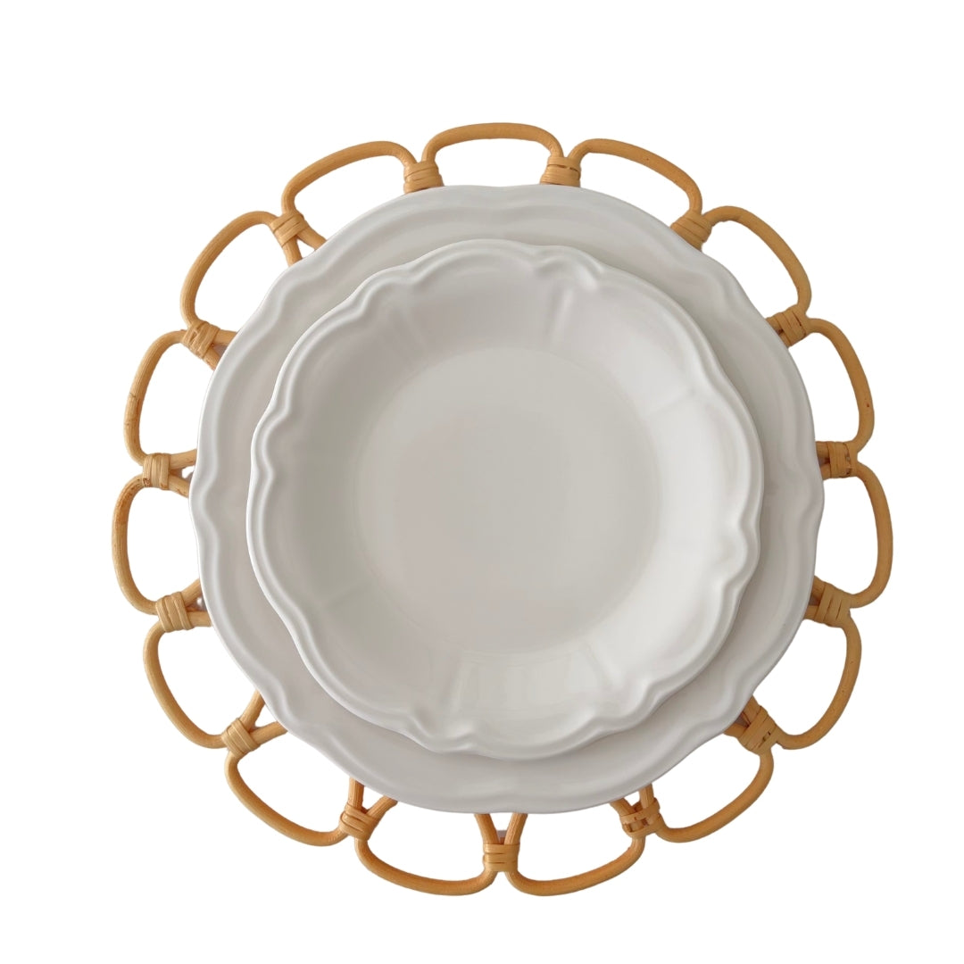 Charlotte 26cm Chalk White Stoneware Dinner Plates stacked on a round natural woven rattan placemat by Matisa Deco.