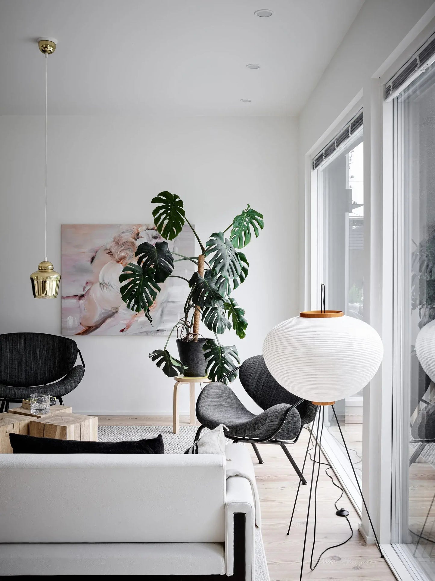 Modern living room with white walls, black chairs, a white sofa, and a large window.