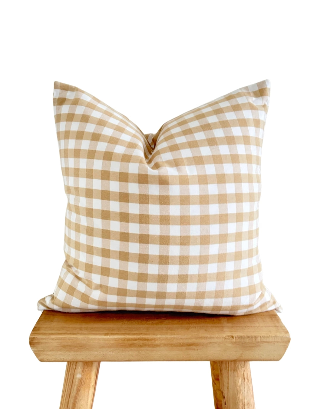 Beige check cushion cover on rustic wood stool, modern farmhouse style.