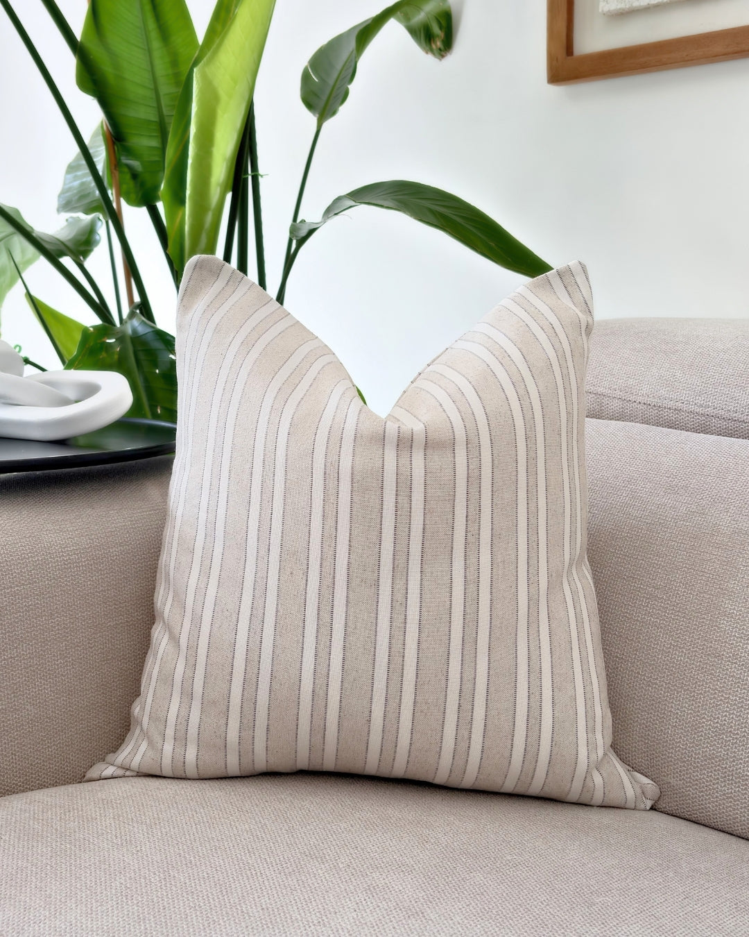 Sophisticated taupe jacquard cushion cover on a neutral beige sofa in a modern, timeless living room.