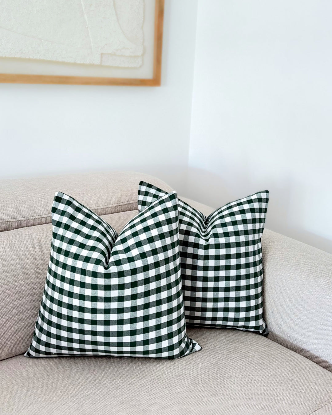 Two green check cushion covers styled on a beige sofa with warm autumn organic home decor accents.