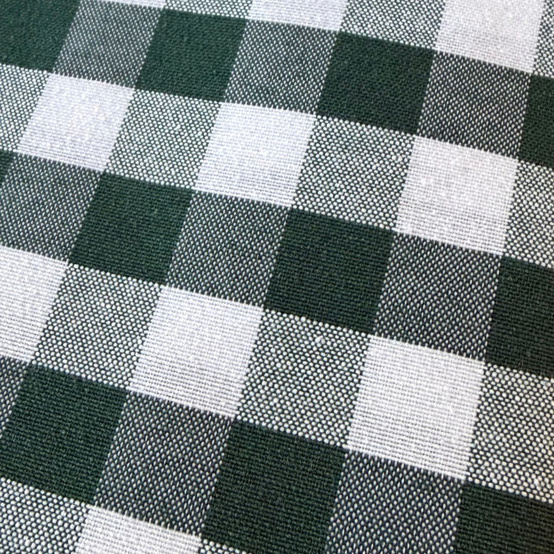 Close up of green gingham tablecloth showing its cotton rich woven texture.