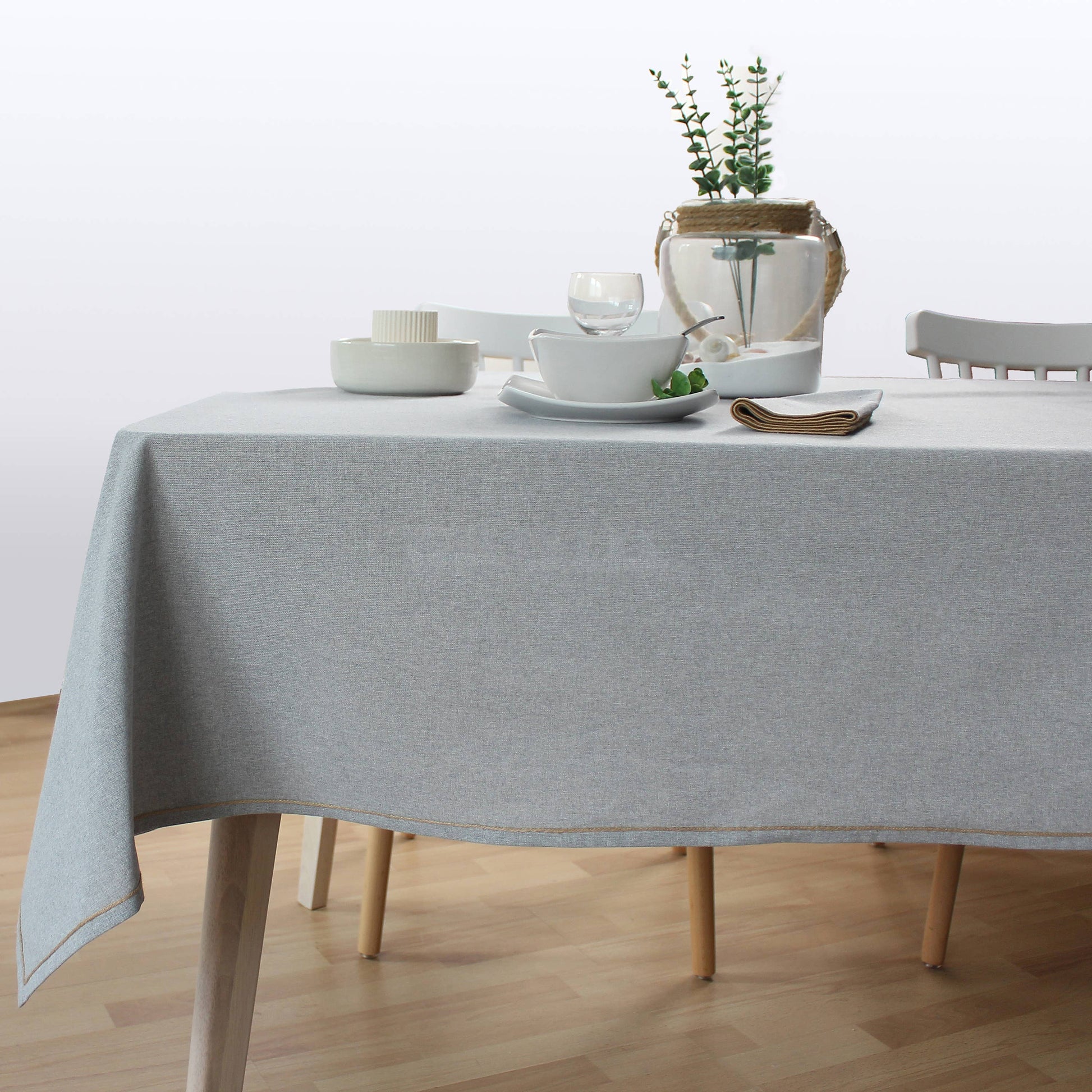 Scandinavian style dining setting with  light grey tablecloth and neutral decor