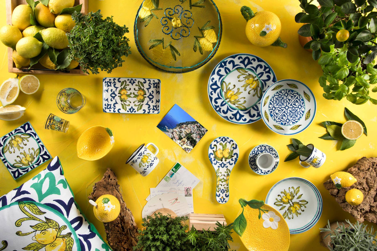 Decorative table setting with ceramic plates, bowls, and lemons on a yellow background