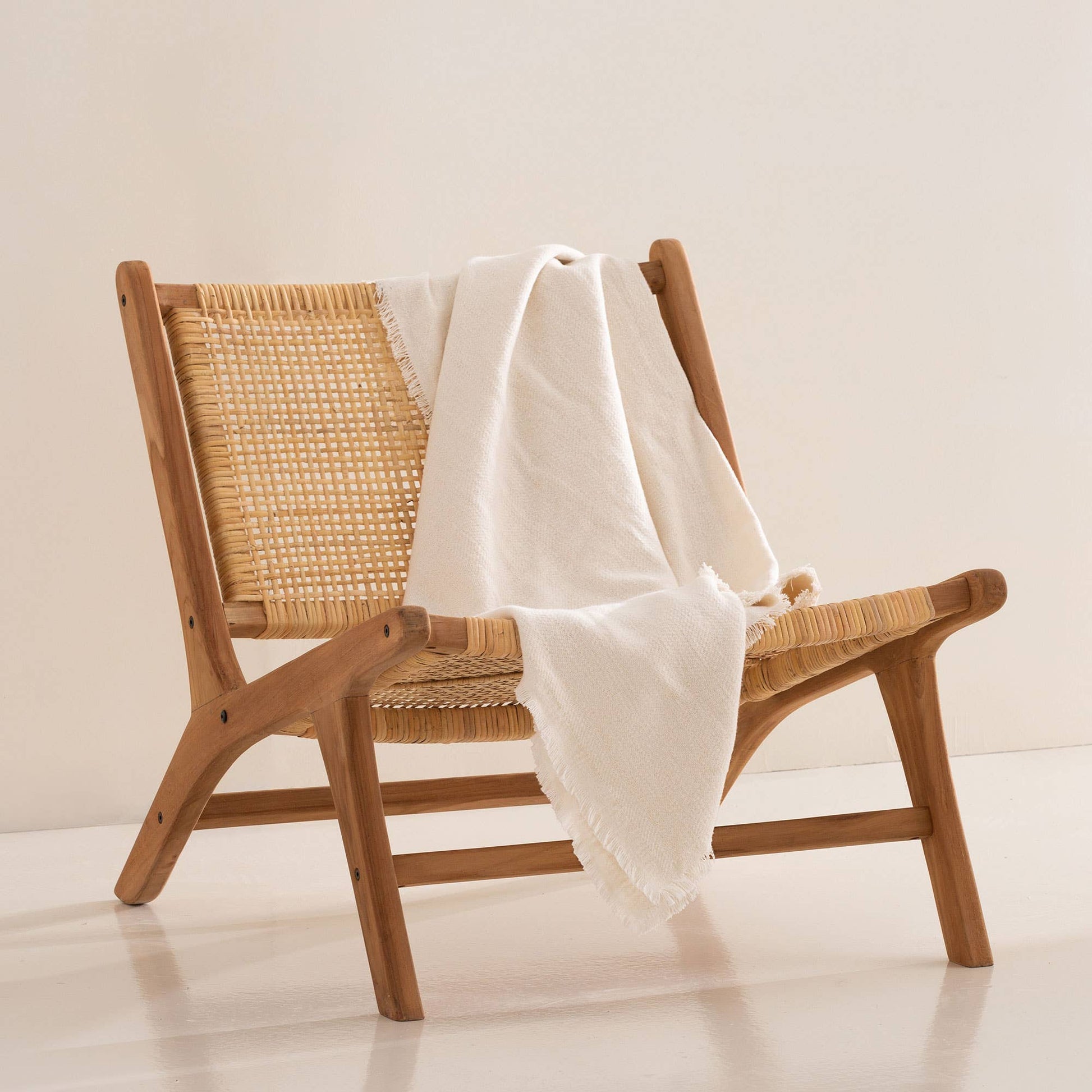 Ecru off-white cotton blanket styled on a bed for a natural and elegant aesthetic.
