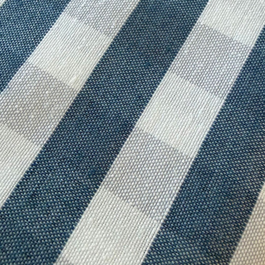 Close up of navy blue and cream gingham tablecloth showing its woven cotton rich fabric texture