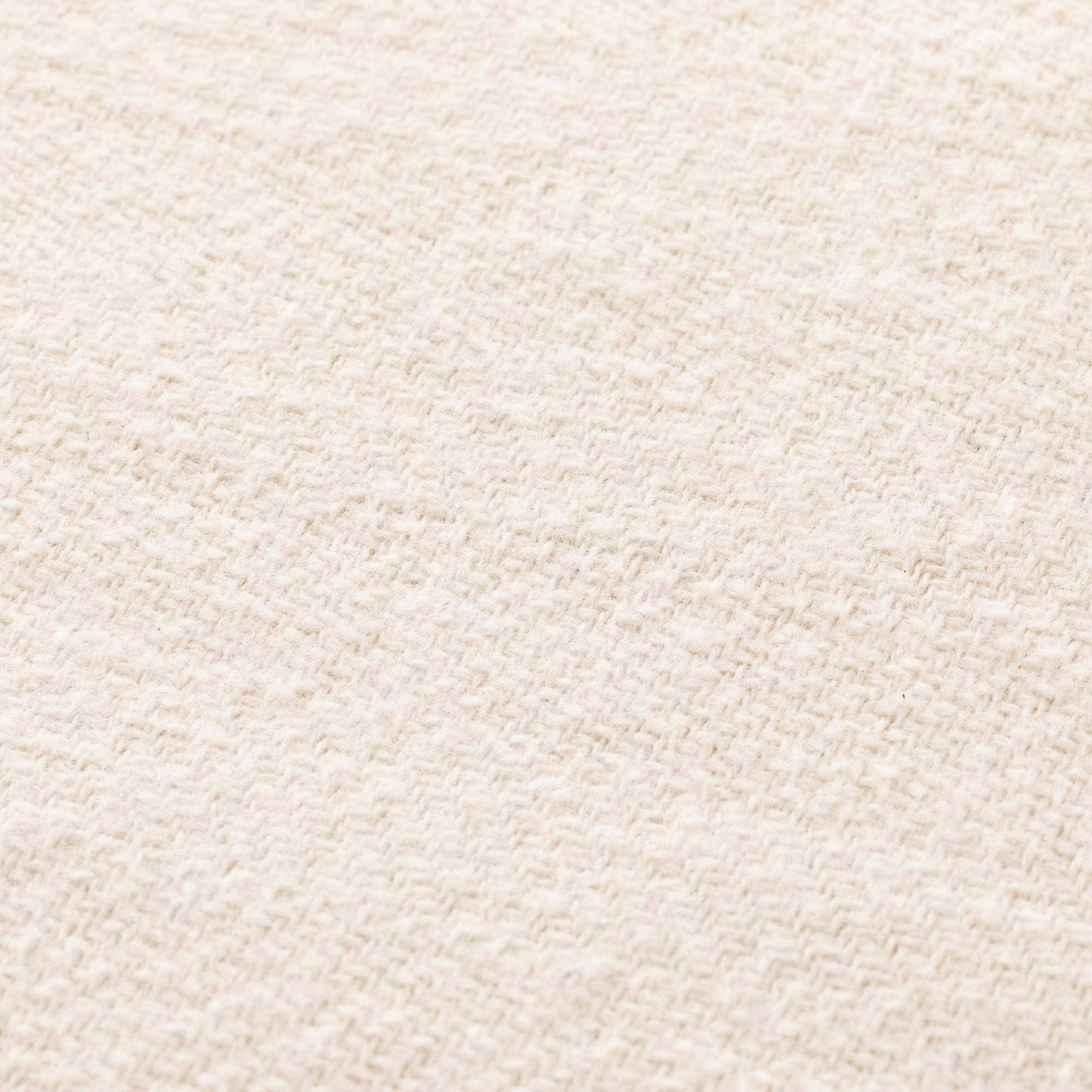 Close-up of the breathable ecru cotton fabric texture on the NATURE collection fringed throw.