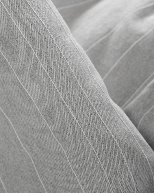 Close-up Detailed view of the fine white linear stripes on grey jacquard cotton fabric.