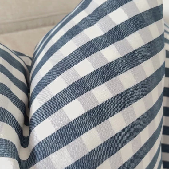 Demonstration of splash-proof water repellent finish on navy blue gingham cushion cover.