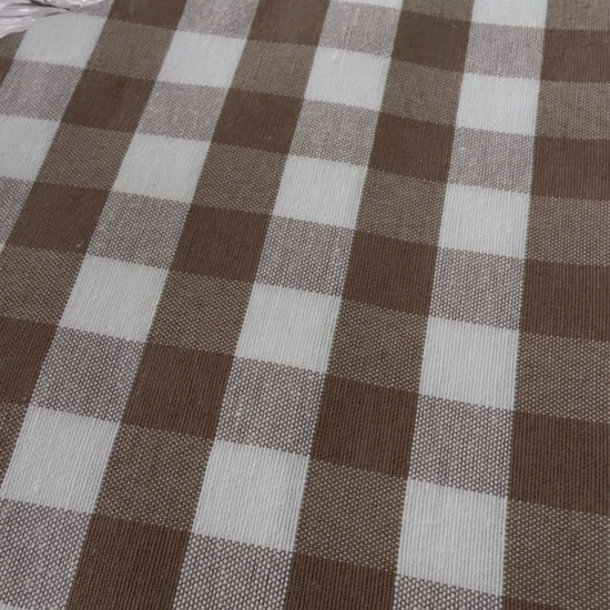 Taupe gingham water repellent tablecloth demonstration showing water beading on the fabric and being wiped away.