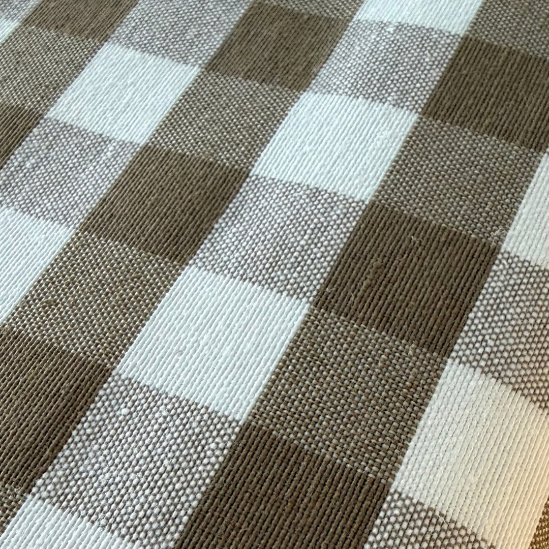 Close up of taupe and white gingham tablecloth textured fabric