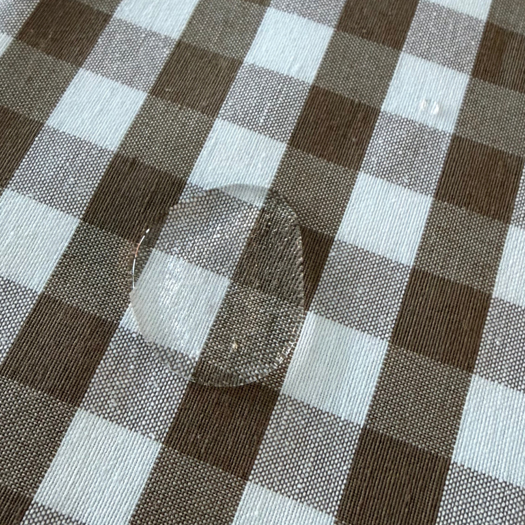 Water droplets beading on taupe gingham water repellent tablecloth