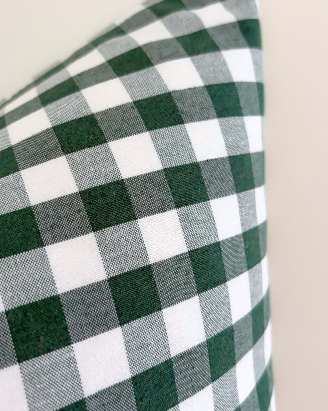 Detailed texture of water-repellent cotton blend fabric showing splash-proof drops on green check pattern.
