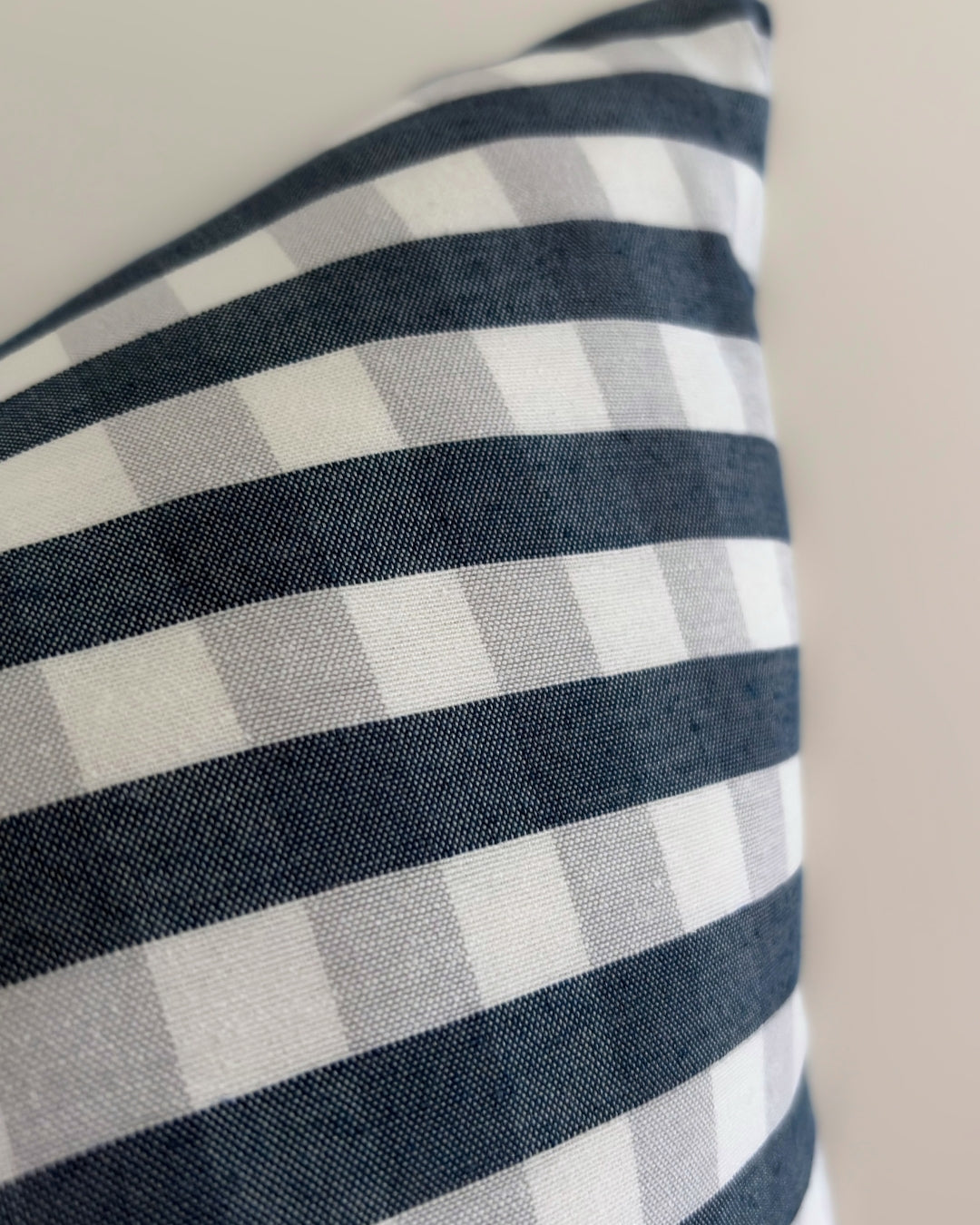 Detailed texture of water-repellent cotton blend fabric showing splash-proof drops on navy blue check pattern.