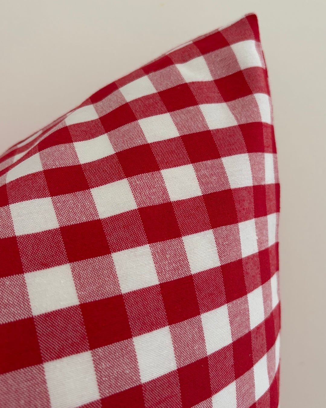 Detailed texture of water-repellent cotton blend fabric showing splash-proof drops on red check pattern.