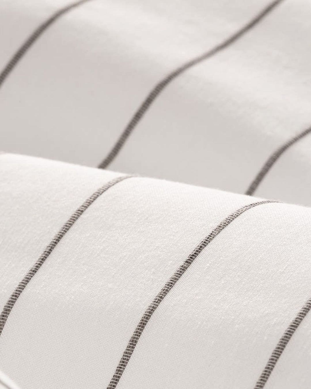 Close-up of the raised decorative jacquard weave and natural cotton texture in white and brown.