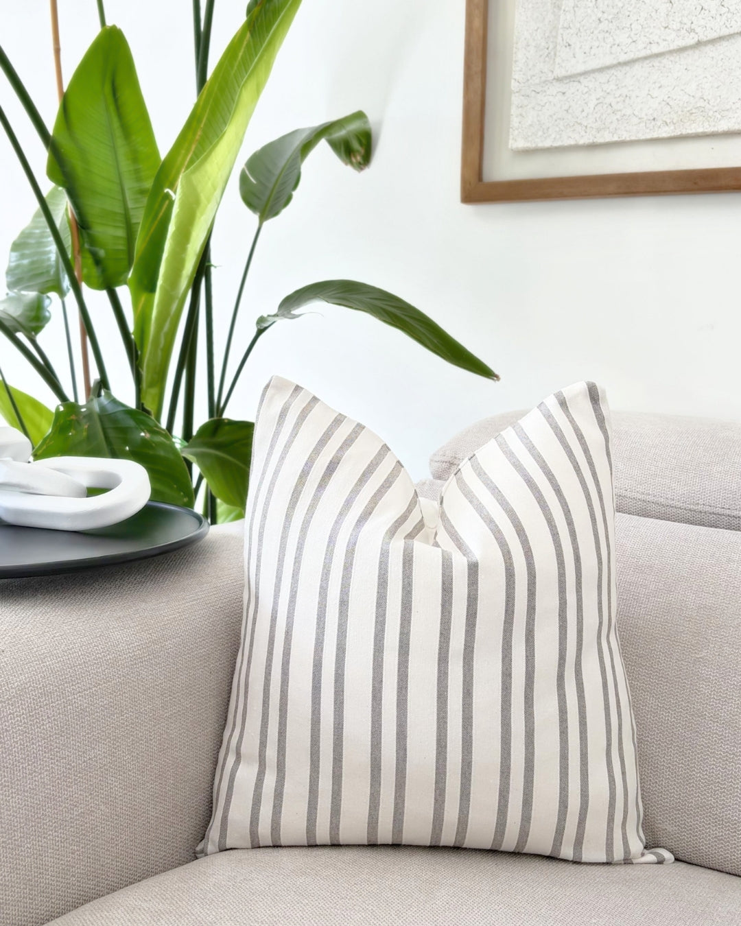 Taupe jacquard cushions arranged on a neutral beige sofa.